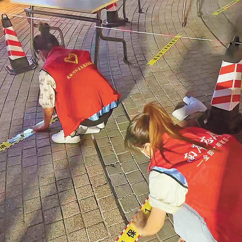 8月23日，南岸区志愿者抓紧时间铺设一米间隔线。（南岸发布供图）
